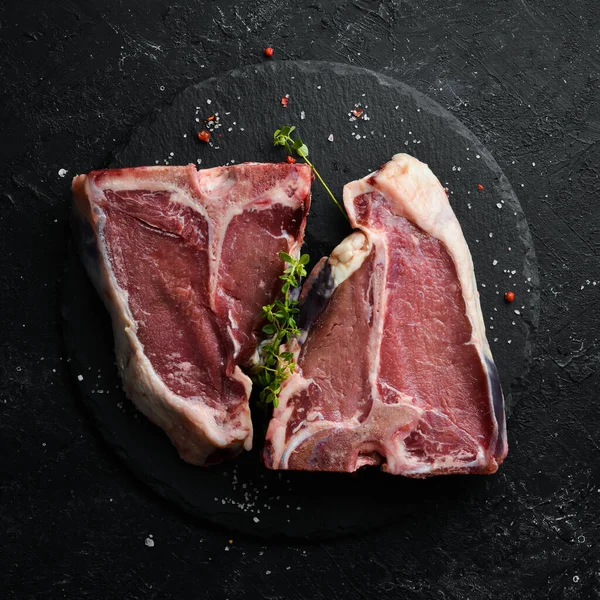 Siyah taştan bir arka planda çiğ biftek. Üst Manzara. Kırsal biçim.