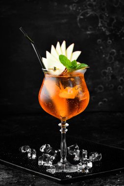 Bardakta kokteyl, Aperol Spretz. Siyah taştan bir arka planda. Menü barı. Alkol..