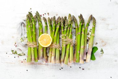 Beyaz ahşap arka planda taze yeşil kuşkonmaz. Sağlıklı yiyecekler. Üst görünüm, ücretsiz kopyalama alanı.