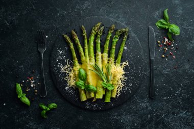 Siyah taş tabakta peynirli ve fesleğenli kuşkonmaz. Üst Manzara. Metnin için boş yer.