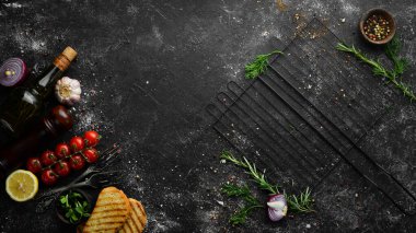 Siyah taş arka plan: barbekü ve baharatlar. Üst Manzara. Boş kopyalama alanı.