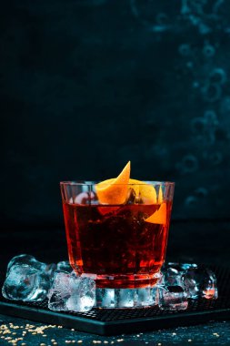 Siyah taş arka planda geleneksel Negroni kokteyli. Menü barı. Alkol..