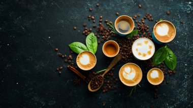 Kahve seti: espresso, cappuccino, latte ve Americano. Siyah taştan bir arka planda. Üst görünüm.