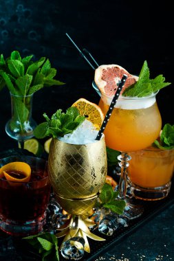 Siyah taşlı arka planda renkli alkollü kokteyller. Menü barı. Alkol..