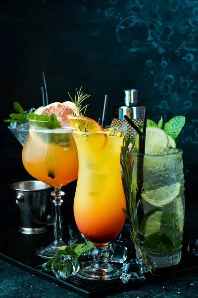 Set of colored alcoholic cocktails on a black stone background. Menu bar. Alcohol.