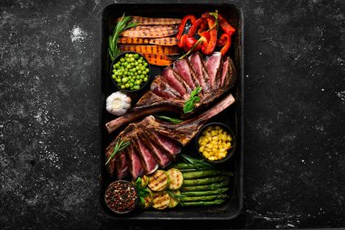 Izgara biftek ve ızgara sebze: kuşkonmaz, mısır, kabak, havuç ve biberiye. Tomahawk. Üst Manzara. Boş kopyalama alanı.