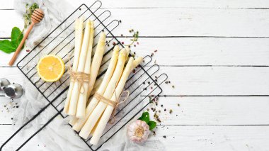 Beyaz ahşap arka planda organik beyaz kuşkonmaz. Sağlıklı yiyecekler. Üst Manzara. Metnin için boş yer.