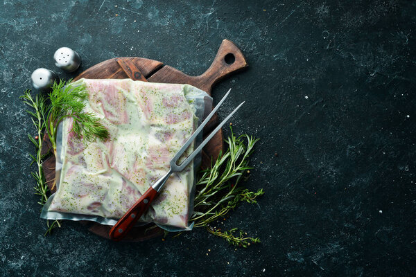 Vacuum packaging with raw marinated ribs in a creamy sauce. Top view. Free space for your text.