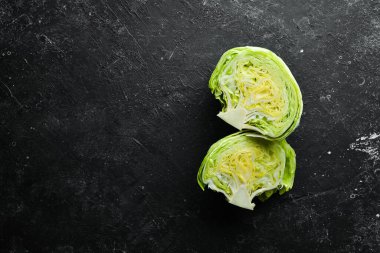 Buzdağı marulu. Siyah taşlı arka planda taze marul. Üst Manzara. Boş kopyalama alanı.