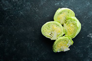 Buzdağı marulu. Siyah taşlı arka planda taze marul. Üst Manzara. Boş kopyalama alanı.