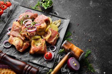 - Et. Çiğ salamura kebap soğan ve baharatla siyah tabakta. Üst Manzara. Boş kopyalama alanı.