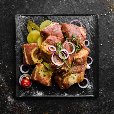 - Et. Çiğ salamura kebap soğan ve baharatla siyah tabakta. Üst Manzara. Boş kopyalama alanı.