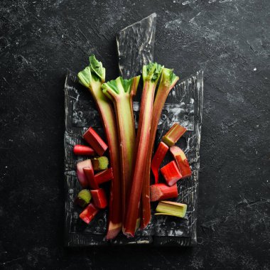 Siyah taşlı arka planda taze ravent doğradım. Üst Manzara. Boş kopyalama alanı.