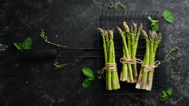 Siyah taştan bir arka planda taze yeşil kuşkonmaz. Sağlıklı yiyecekler. Üst görünüm, ücretsiz kopyalama alanı.