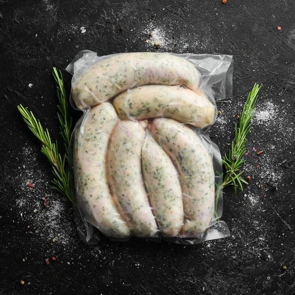 Raw pork sausages in vacuum packaging. Top view. On a black background.