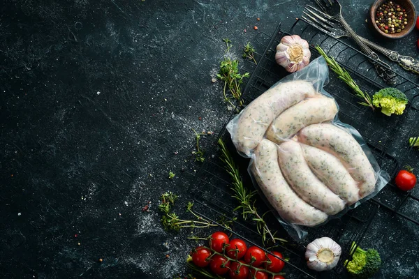 Raw pork sausages in vacuum packaging. Top view. On a black background.