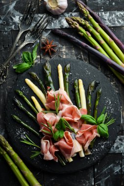 Haşlanmış kuşkonmaz ve siyah taş tabakta baharatlı jambon. Üst Manzara. Metnin için boş yer.