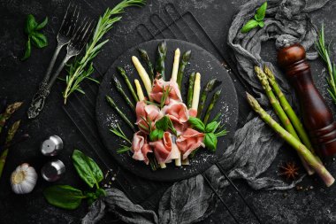 Haşlanmış kuşkonmaz ve siyah taş tabakta baharatlı jambon. Üst Manzara. Metnin için boş yer.