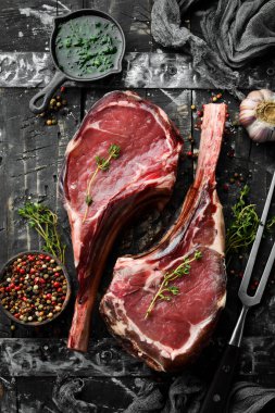 Baharatlı kurutulmuş çiğ baltalı biftek. Siyah tahta bir arka planda. Üst Manzara. Boş kopyalama alanı.