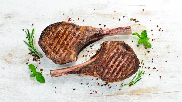 Tamahavk Steak Kosti Kořením Bylinkami Bílém Dřevěném Pozadí Horní Pohled — Stock fotografie