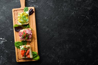 Tahta tahtada sebzeli ve somonlu sandviçler. Üst Manzara. Kırsal biçim.