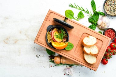 Soğanlı kaz ciğeri ve metal sürahide elmalar. Üst Manzara. Kırsal biçim.