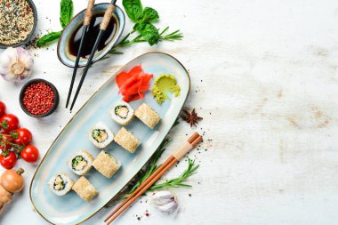 Salatalıklı rulo, tabakta balık ve peynir. Suşi. Üst Manzara. Kırsal biçim.