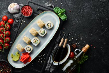 Salatalıklı rulo, tabakta balık ve peynir. Suşi. Üst Manzara. Kırsal biçim.