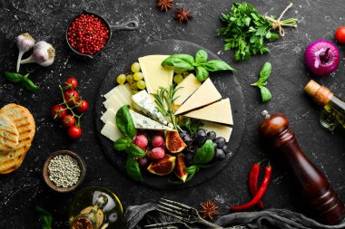 Tabakta çeşitli peynirler var. Parmesan peyniri, mavi peynir ve üzümlü ve incirli peynir. Antipasto. Üst görünüm.