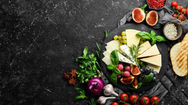 Tabakta çeşitli peynirler var. Parmesan peyniri, mavi peynir ve üzümlü ve incirli peynir. Antipasto. Üst görünüm.