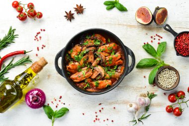 Domates soslu tavuk filetosu ile fırında mantar. Siyah taştan bir tabakta. Üst görünüm.