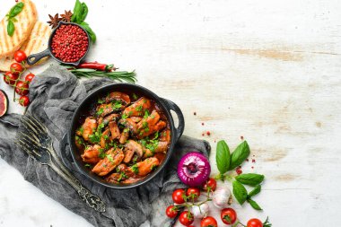 Domates soslu tavuk filetosu ile fırında mantar. Siyah taştan bir tabakta. Üst görünüm.