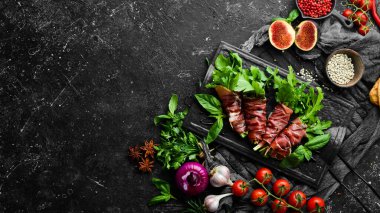 Siyah taş tabakta roka ve balzamik soslu Prosciutto. Antipasto. Üst görünüm.