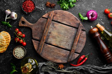 Siyah taş pişirme arka planı. Baharat ve sebze. Üst Manzara. Metnin için boş yer.