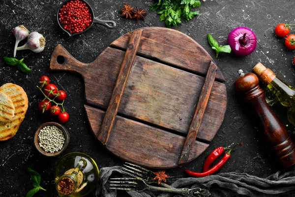 Siyah taş pişirme arka planı. Baharat ve sebze. Üst Manzara. Metnin için boş yer.