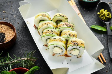 Salatalık, susam ve Philadelphia peynirli suşi. Japon yemeği. Geleneksel suşi. Üst görünüm.