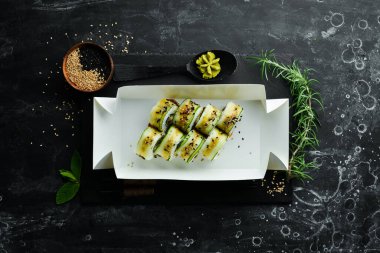Salatalık, susam ve Philadelphia peynirli suşi. Japon yemeği. Geleneksel suşi. Üst görünüm.