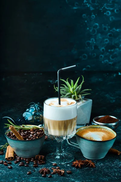 Coffee set: coffee beans, latte coffee and cappuccino. On a black background. Top view.