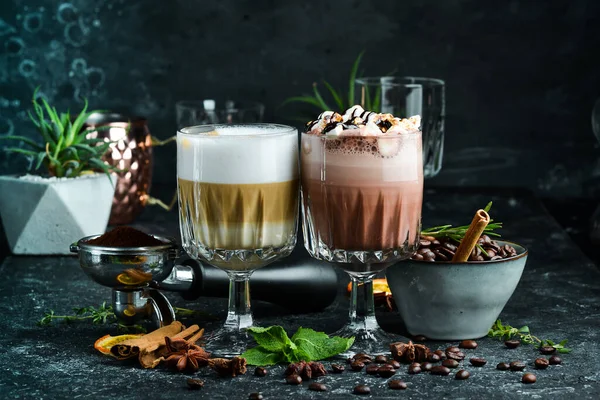 Coffee set: cocoa and hot chocolate with coffee beans. On a black background. Top view.