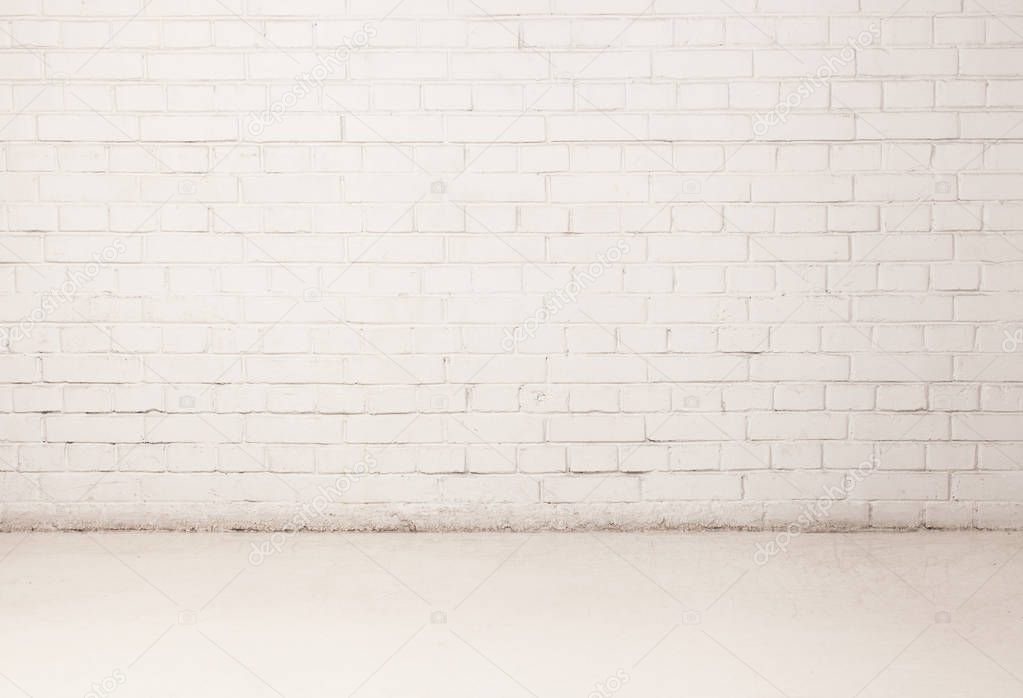 Blank white brick wall with a piece of light floor. Copy space text.