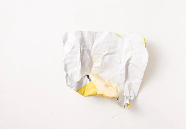 Butter in an open package on a white background.. Copy space text