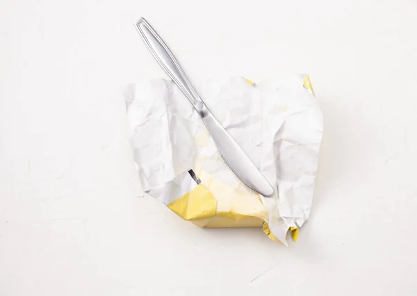 Butter in an open package on a white background.. Copy space text
