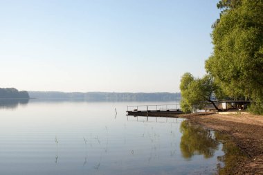 Orman göl üzerinde bekletin. Balıkçılık Gölü kıyıdan sis sabahın erken saatlerinde görüntüleyin. Metin için yer.