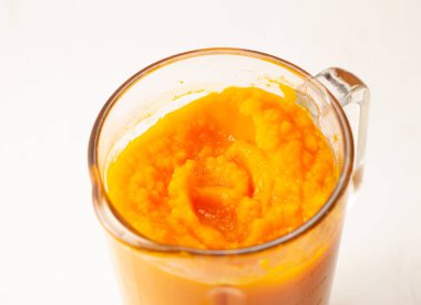 Hafif bir arka plan üzerinde bir karıştırıcıda kabak püresi yemek. Metin için yer.