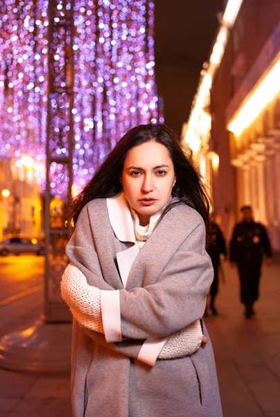 The girl walks around the evening city with lighted lanterns in the autumn