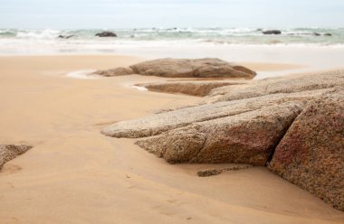 Kumlu sahilde büyük granit taşlar. Arka plan görüntüsü. Alan metni kopyalayın