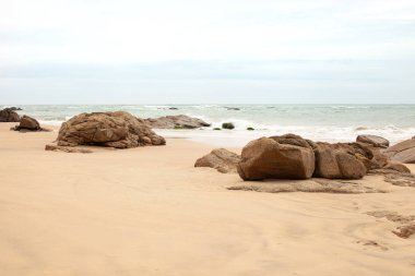 Kumlu sahilde büyük granit taşlar. Arka plan görüntüsü. Alan metni kopyalayın