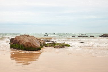 Kumlu sahilde büyük granit taşlar. Arka plan görüntüsü. Alan metni kopyalayın