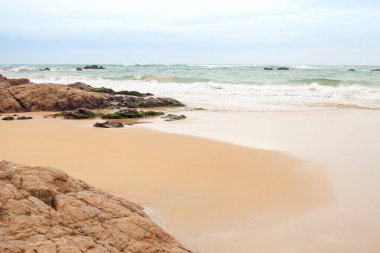 Kumlu sahilde büyük granit taşlar. Arka plan görüntüsü. Alan metni kopyalayın