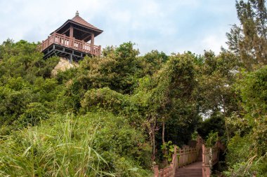 Kayalar ve tropikal yeşil arasında bir görüntüleme platformu ile deniz kıyısında ahşap merdiven